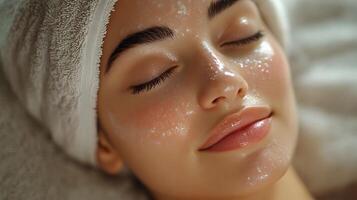 A person receiving a soothing facial treatment with soft lighting, clean background for copy. photo