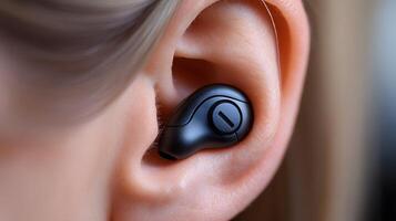 A person adjusting their hearing aid, focusing on the device's detailed mechanism, with soft background blur and wide copy space. photo