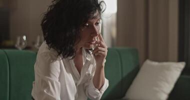 Woman using laptop and making notes during phone call video