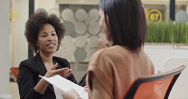 Businesswomen discussing data in office video
