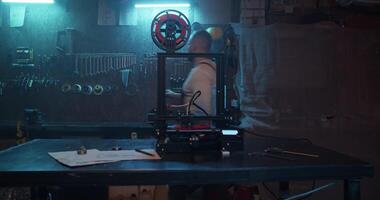Repairman taking wrench from stand in workshop with 3D printer video