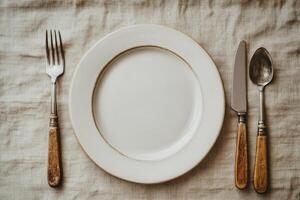 An empty plate with a fork and knife on top photo