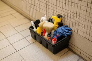 A black container with cleaning supplies on the floor photo