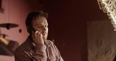 Wine bar owner talking to client reserving table on cellphone video