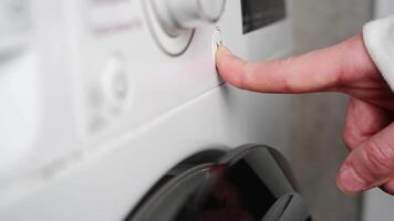 Finger pushing power button on washing machine video