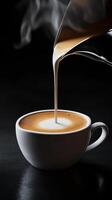 steaming cup of coffee with milk being poured, creating beautiful swirl. dark background enhances rich colors and textures of beverage photo