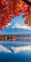 Majestic mountain reflection in serene lake surrounded by vibrant autumn foliage. clear blue sky enhances beauty of this tranquil landscape photo