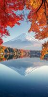 Majestic Mount Fuji reflected in serene lake, surrounded by vibrant autumn foliage. scene captures beauty of nature in tranquil setting photo