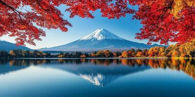 Majestic Mount Fuji reflected in serene lake, surrounded by vibrant autumn foliage. photo