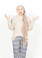 A woman in a beige sweater and scarf is standing with her hands out photo