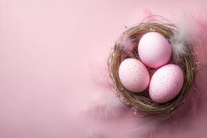 Easter eggs in a nest on a pink background with feathers. photo