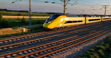 A modern high-speed yellow train runs quickly outside the city in the summer video