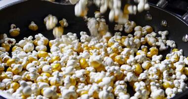 popcorn being fried and stirred in a pan with dramatic lighting close-up video