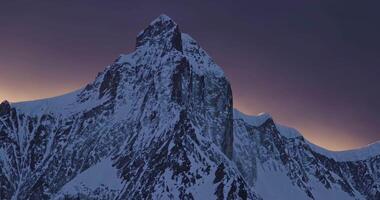 drone shot of snowy peak of high mountain at dusk at dawn video