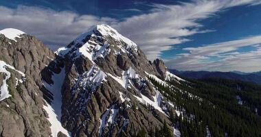 Drone view of snowy peak of high mountain with trees video