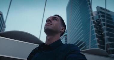 Man exploring futuristic architecture in vibrant city, architecture sparking inspiration as man looks upward, architecture fueling creative perspective, trendy modern design or urban tourism. video