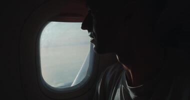 Passenger in airplane enjoying sky view, passenger intrigued by travel possibilities, passenger embracing tranquil long-distance journey, perfect for flight marketing visuals worldwide. video