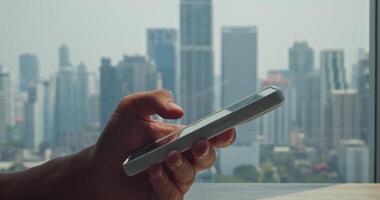 Man typing messages amid towering buildings, city shaping energetic backdrop for rapid communication, city fueling instant responses and collaboration, great for fast-moving urban visuals. video