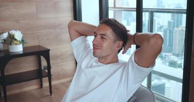 Portrait of relaxed business man in white shirt resting during break at work, put hands behind head lean on comfy chair relaxing alone at home, breath fresh air-conditioned air enjoy video