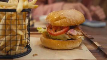 Burger with crispy bacon and fresh toppings, capturing savory moment of indulgence under vibrant outdoor atmosphere. Burger shines as mouthwatering highlight, ideal for enticing culinary promotions. video