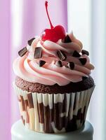 A cupcake with chocolate and cherry frosting photo