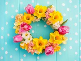 Vibrant spring flower wreath featuring tulips, daffodils, and other blossoms on a bright blue polka dot background photo