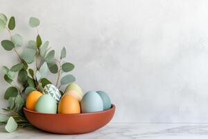 Creating a minimalist Easter centerpiece with simple colored Easter eggs on marble countertop featuring eucalyptus leaves for a fresh, seasonal decoration idea photo