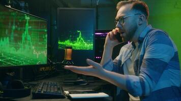 wütend kaukasisch Krypto Händler Mann Kerl Entwickler Arbeiter Sprechen zwei Handy, Mobiltelefon Telefone Mitarbeiter diskutieren Markt Statistik männlich streiten beim Zuhause Nachtzeit Arbeit gereizt Makler Streit mit Klient Ärger Neon- video
