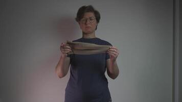 Woman puts on compression sleeve on arm to support vein health and prevent thrombosis. Compression wear aids circulation, helping reduce risks of varicose veins, blood clots, and pulmonary embolism. video
