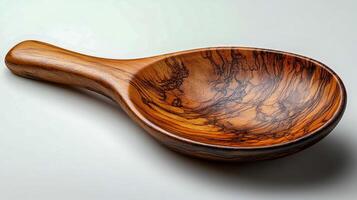 Large wooden spoon with patterns in natural finish on clean light background photo