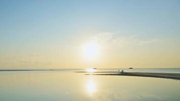 Timelapse beautiful coastal scenery at Koh Samui during sunset. Fast motion footage of many people walking on the beach during low tide with dramatic sky reflected on water surface. video