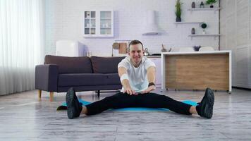 Sport exercises at home. A man does a warm-up before starting to exercise video