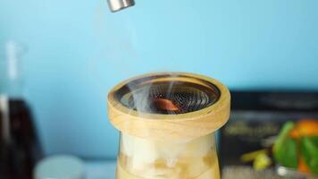 Professional bartender wielding butane torch, igniting cocktail within glass container, creating dramatic fire effect during drink preparation at bar setting video