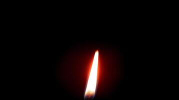 Single candle flame glowing in darkness with subtle warm light. Light concept video