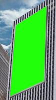 Green chroma key blank vertical billboard mock up in city mall for advertising on skyscrapers with beautiful clouds background video
