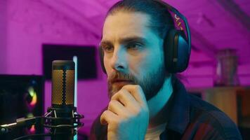 Contemplative Caucasian vlogger gamer blogger man contemplate at home guy brainstorming streamer thinking about game cyber sport male addict influencer pondering coming to decision solution idea neon video
