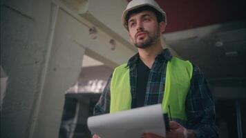 Serious Caucasian male engineer mechanic builder man writing tablet foreman guy planning draft structure in factory workshop architect drawing blueprint inspector worker industrial production control video