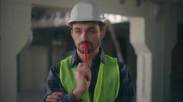 Thoughtful pensive Caucasian man thinking ponder male builder engineer guy holding marker to face construction building plan project architect worker solution foreman repairman architecture decision video
