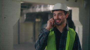 Cheerful Caucasian employee man handyman workman guy builder speaking conversation mobile phone in factory construction happy architect talking device male engineer call laborer work industry service video