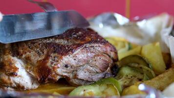 Process of cutting the steak with a large kitchen knife on a cutting board. The juicy beef meat is cut into pieces. video