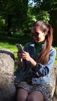 Beautiful Girl Browsing Phone on Sunny Day in Park, Smiling and in Good Mood video