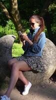 Beautiful Girl Browsing Phone in Park on Sunny Day, Smiling and in Good Mood video