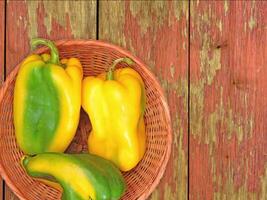 A basket with yellow and green peppers on a wooden table video