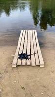 Summer shoes standing on a wooden bridge on a riverbank in summer video