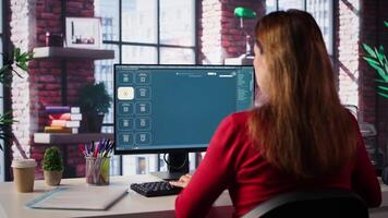 Technician employs AI chatbot on pc monitor and executing programming code. IT freelance expert using coding software and artificial intelligence to write and test code in her apartment. Camera B. video