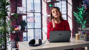 Female freelancer at home calling her team members to discuss online research and surfing the internet, utilizing a laptop for telework. Staying connected on telephone line call. Camera B. video
