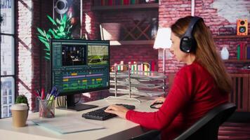 creator woman editing a music on dual monitors in loft studio, multitasking between timeline editing and color grading. Professional editor uses tech tools and software. Camera B. video