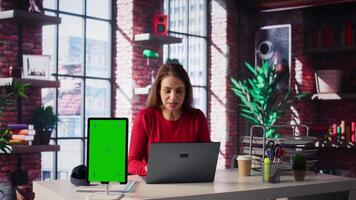 Woman organizing and planning activities on the agenda next to chroma key, overseeing time management for the schedule by using online tools as weekly planner and digital calendar. Camera B. video