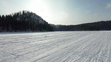 A snowy field with trees and mountains in the background video