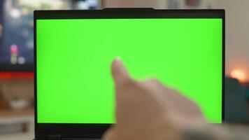 Reading and Pointing Laptop with Blank Green Screen in a Bright Workspace video